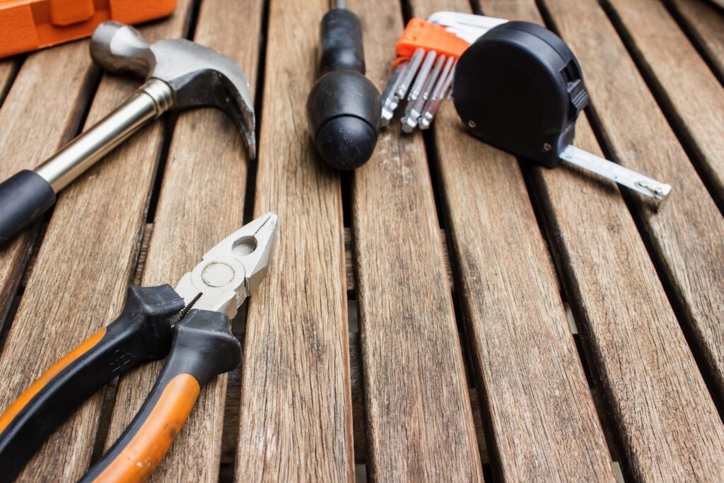 assorted-type carpentry tools on brown surface