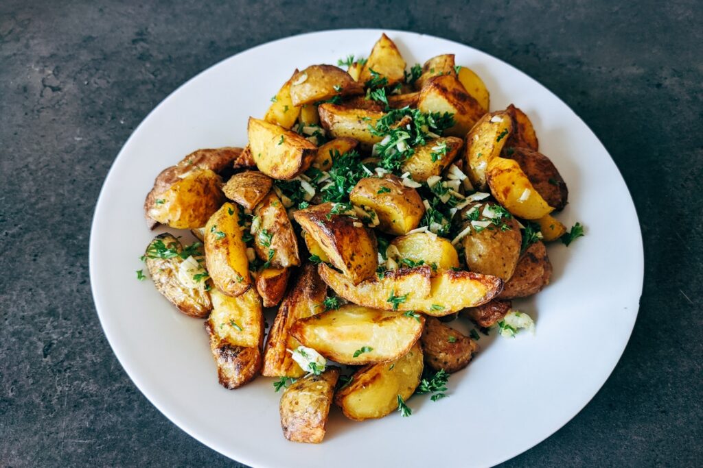 a white plate topped with potatoes and parsley